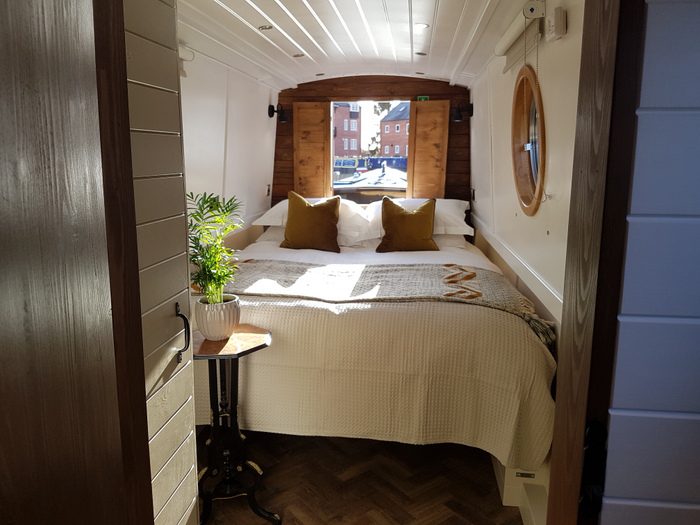 King sized bed in the front of Boutique Narrowboat Woodland Grayling